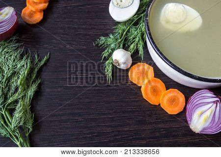 Soup with sorrel vegetables and boiled egg red onion carrots garlic dill on dark wooden table