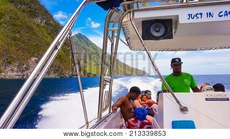 Saint Lucia, Saint Lucia - May 12, 2016: The people enjoying of boat trip to the mountains Pitons near a beautiful caribbean beach at Saint Lucia island at Caribbean at May 12, 2016