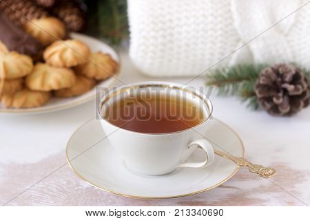 Winter Composition With Tea And Biscuits In The Background Of A Rug Or Pullover, Cones And Fir Branc