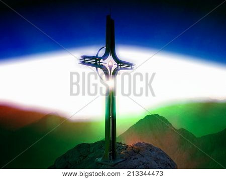 Cross Raised  At Mountain Summit. Sharp Peak, Daybreak Sun In Sky.