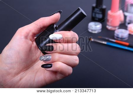 Black, white Nail art manicure. Holiday style bright Manicure with sparkles. Bottle of Nail Polish. Beauty hands. Stylish Nails, Nail Polish.