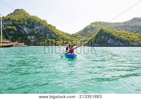 Two women are mother and daughter. Travel by boat with a kayak happy on the sea under the bright summer sky front of Ko Wua Ta lap islands 