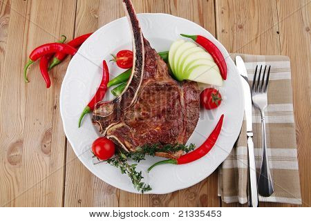 cibo di carne: manzo alla griglia di ricambio rib su piatto bianco con pepe timo e pomodoro sul tavolo di legno