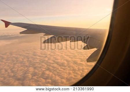 The View From The Airplane On The Left Wing, Above The Clouds Concept Of Vacation, Flight, Trip Clos