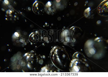 light shining on bubbles on a black background