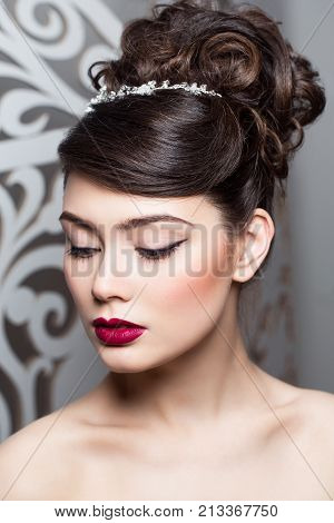 beautiful brunette young woman in white wedding gown. bride with fashion hairstyle. studio shot.