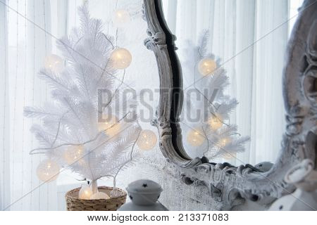 Mirror In An Old Frame And A White Christmas Tree