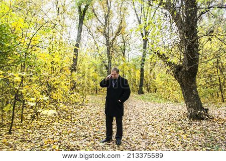 Handsome Young Man With A Smartphone On The Street Talking In The Park.