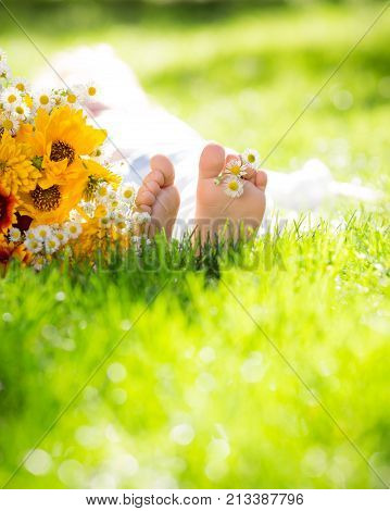 Сhildren`s feet with spring flower on green grass