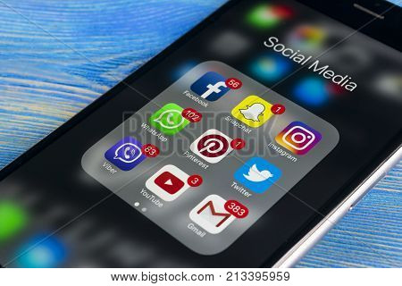 Sankt-Petersburg Russia November 11 2017: Apple iPhone 7 on wooden table with icons of social media facebook instagram twitter snapchat application on screen. Smartphone Starting social media app.