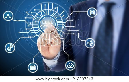 IT expert in a blue suit clicks on a circuit diagram with the words edge computing surrounded by specific icons
