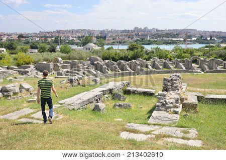 A man in a striped T-shirt on the ruins of the ancient Roman city