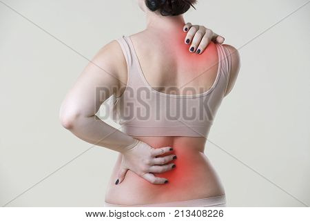 Back pain woman with backache on beige background studio shot