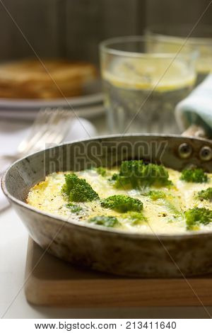 Omelette with broccoli and cheese served with bread toasts and lemonade. Selective focus.