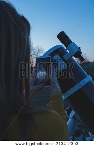 Photographing the Moon through a telescope with cellphone.