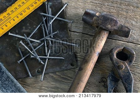 Nails nail pullerruler and hammer on a wooden table