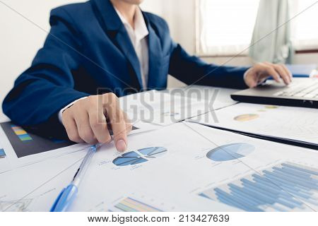 Business and finance investment concept : Businessman check about cost and doing finance graph report at office Finance managers taskBusinessman recheck new plan financial graph data.