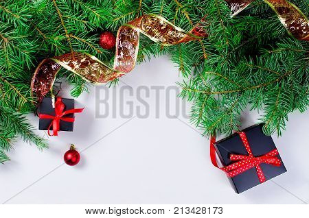 Black and red Christmas background. black gift box balls fir branchesred Christmas decorations on the white background copy space
