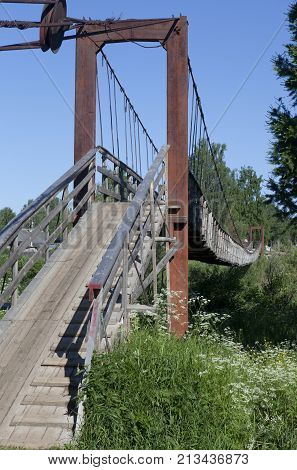 Suspension bridge over the river Vaga in the village Verkhovazhye of Vologda region, Russia