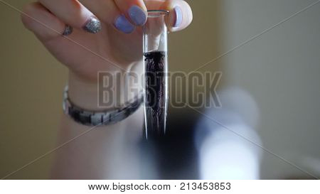 Laboratory tests with test tube and small pipette filled with black liquid, water contamination, experiment. Black liquid in a test tube.