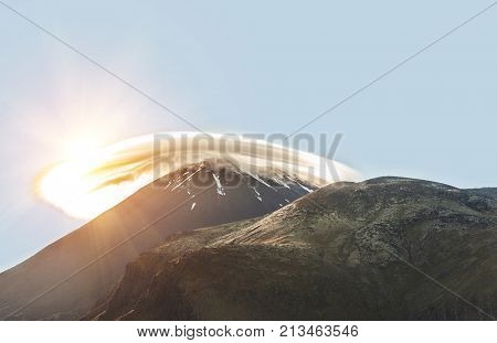 Mount Ngauruhoe with a cloud cap in a morning sun. It is a famous stratovolcano in a Tongariro national park, New Zealand
