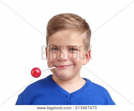 Boy happy in a blue sweater holds a lollipop in his mouth behind a wand close-up on a white isolated background