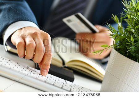Male arms hold credit card press buttons making transfer closeup. Anti-fraud financial security when entering client discount program number or filling personal credential password login to account