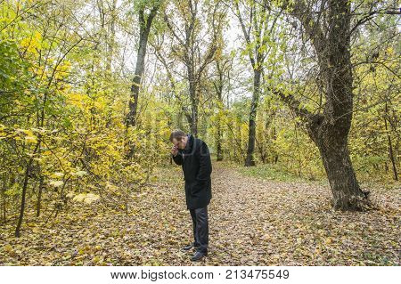 Handsome Young Man With A Smartphone On The Street Talking In The Park.