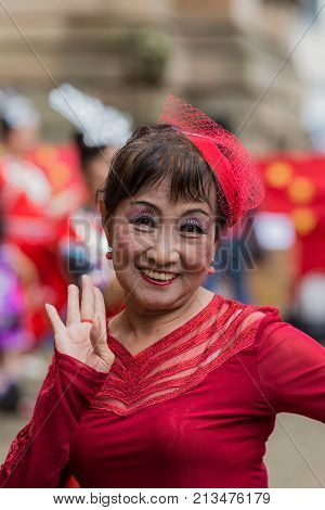 Sydney Australia - March 25 2017: Head shot of Chinese woman living in Australia welcomes Chinese Premier Li Kequing with traditional dances songs and music. Public square side of Town Hall.