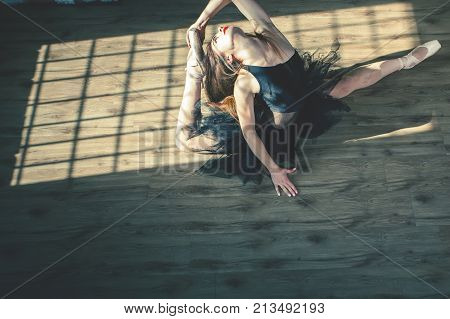 Young beautiful ballerina is posing at vintage studio. Tiptoe dancing. Classical ballet art.