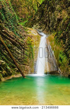 Waterfall and lake in the ravine Chudo-Krasotka in summer day Sochi Russia