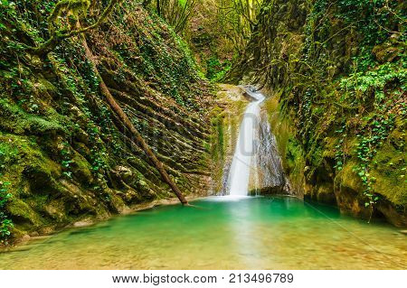 Waterfall and lake in the ravine Chudo-Krasotka in summer day Sochi Russia