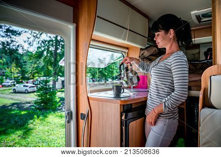 Woman cooking in camper, motorhome interior. Family vacation travel, holiday trip in motorhome RV, Caravan car Vacation.