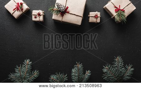 Christmas card. Symmetrically arranged gifts at the top and green fir branches at the bottom of the image. Space for Christmas greeting message.