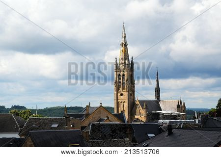 church of arlon over the roofs of the old town against a cloudy sky with copy space belgium europe