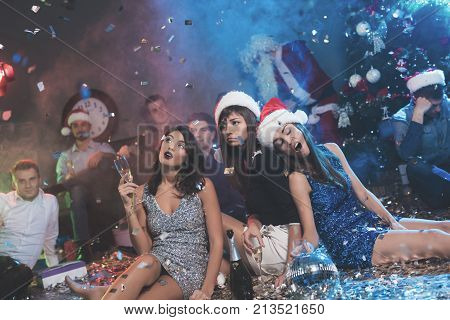 Three Girls Are Sitting On The Floor And Are Bored. They Are Very Tired After A Tumultuous Party For