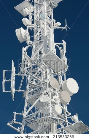 Communication transmitter tower with thick ice layer frost in cold winter