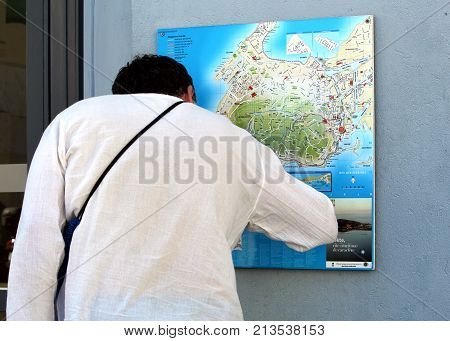 Sete, Herault, France  - Aug 21 2017: Man, A Tourist, Looking At A Street Map Of Sete In Languedoc,