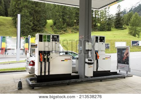 Swiss And Traveler People Fill Oil To Tank Of Car In Petrol Station At Villages Of Tschlin And Ramos