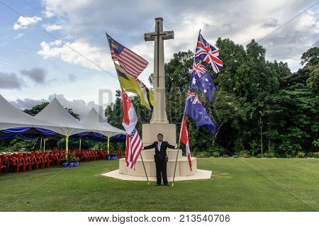Labuan,Malaysia-Nov 12,2017:Man holds the Canada,Australia,Great Britain,India & New Zealand flag during the Remembrance Day at Labuan War Memorial park in Labuan,Malaysia.This event is held every year in November in remembrance of the unsung heroes.