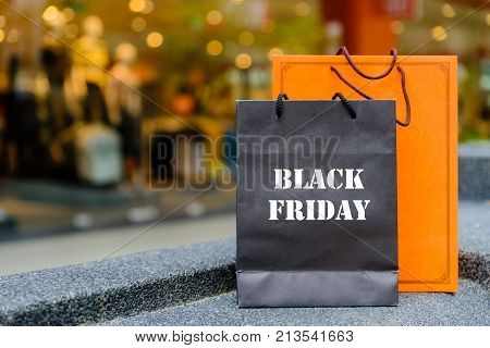Shopping bags with Black Friday words concpt againts shopping mall background.