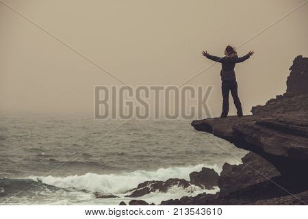 Woman standing on a cliff.