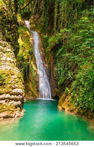 Waterfall and lake in the ravine Chudo-Krasotka in sunny summer day Sochi Russia