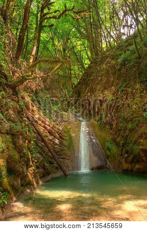 Waterfall and lake in the ravine Chudo-Krasotka in sunny summer day Sochi Russia