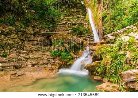 Waterfall and small lake in the ravine Chudo-Krasotka in summer day Sochi Russia