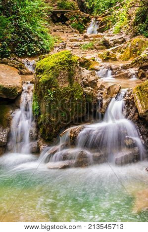 Waterfall and small lake in the ravine Chudo-Krasotka in summer day Sochi Russia