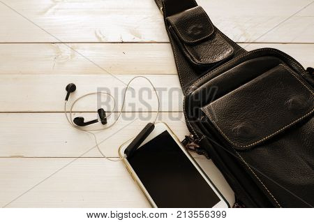 Travel leather black bag and set of smart phone on white  wooden table  ,top view for copy space and concept for travel