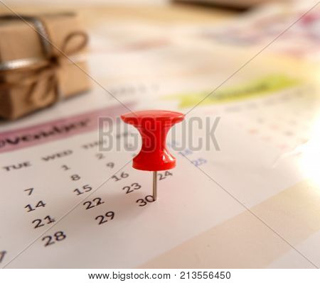 Calendar with red pin with gift box for planning concept for business
