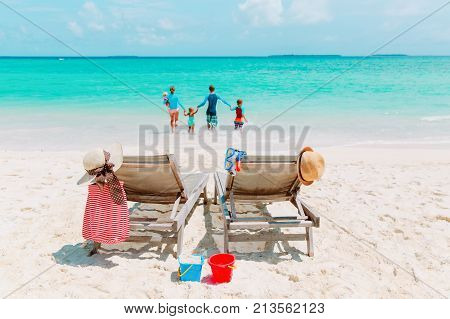 family beach vacation- family with kids play having fun on beach