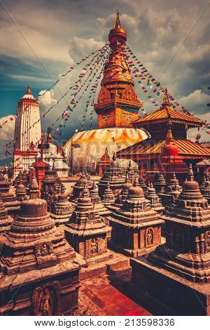 The famous Buddhist stupa at Boudanath in Kathmandu valley, Nepal. Was built in the 14th century. Blue cloudy sky in the background. Travel, holiday. Vintage retro toning filter orange color